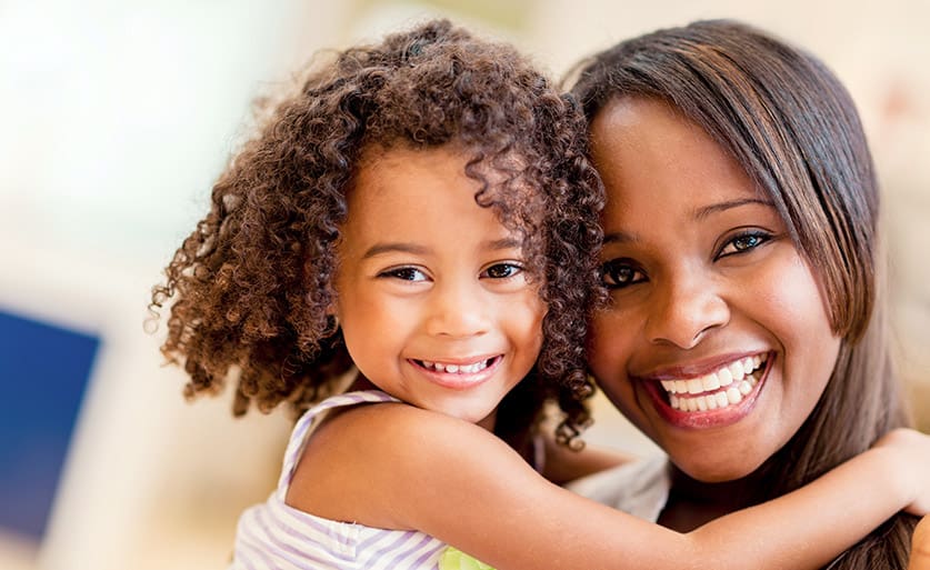 Mother and daughter smiling with healthy teeth